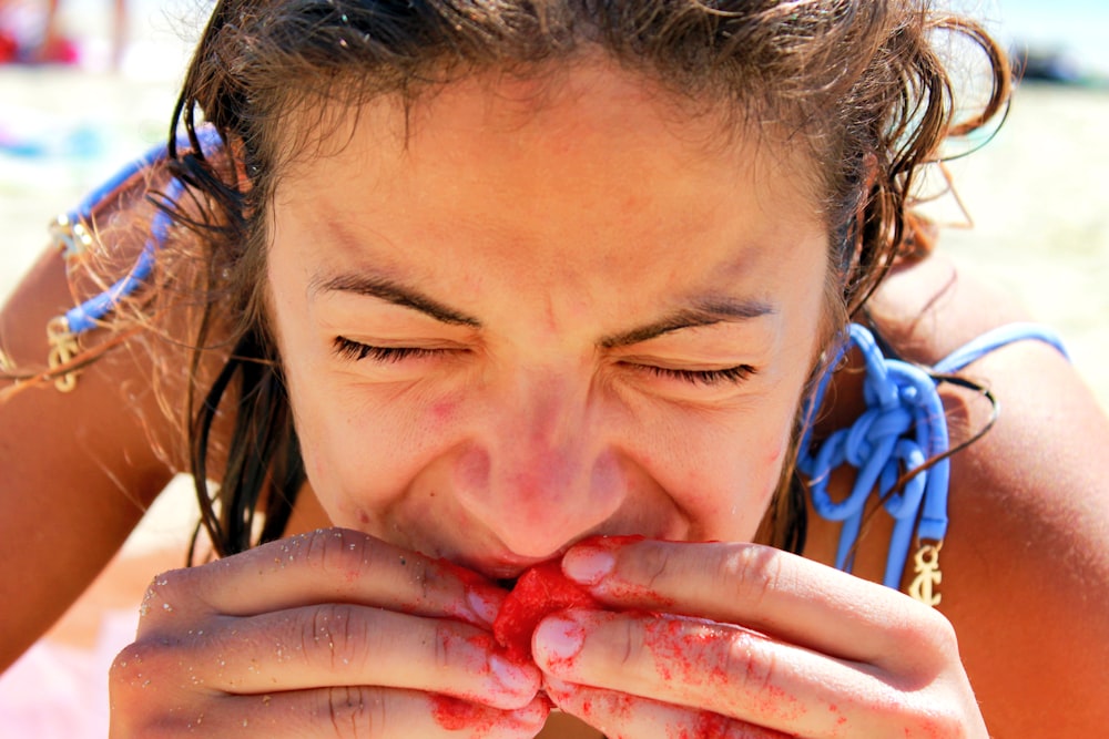 girl covering her face with red paint