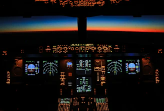 A cockpit view at dawn, instruments glowing softly against a navy sky.