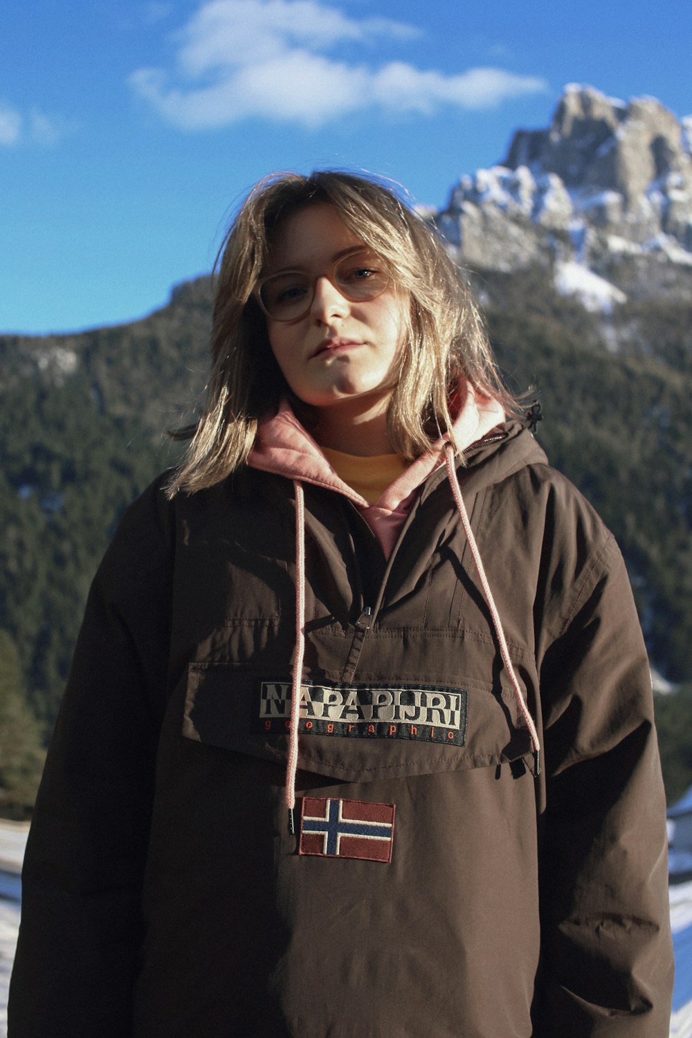 woman in black zip up jacket standing near mountain during daytime