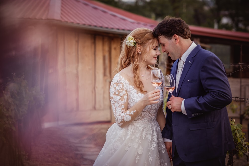 man in black suit holding woman in white floral dress