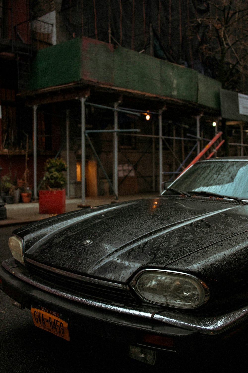 black car parked near green building