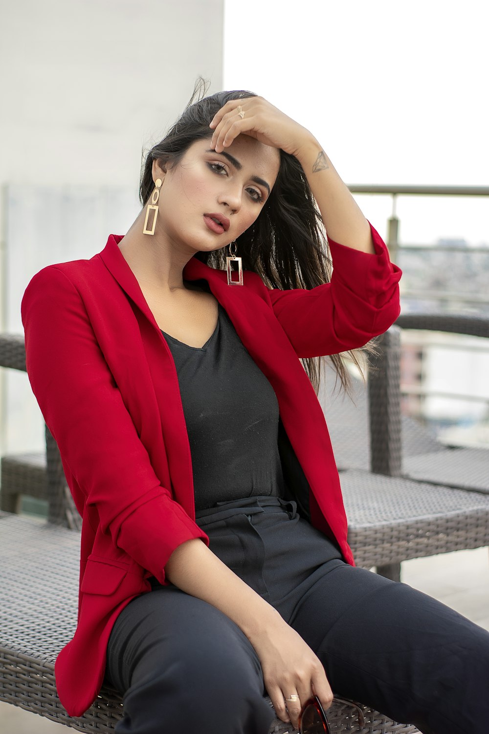 donna in blazer rosso e camicia nera seduta sul pavimento