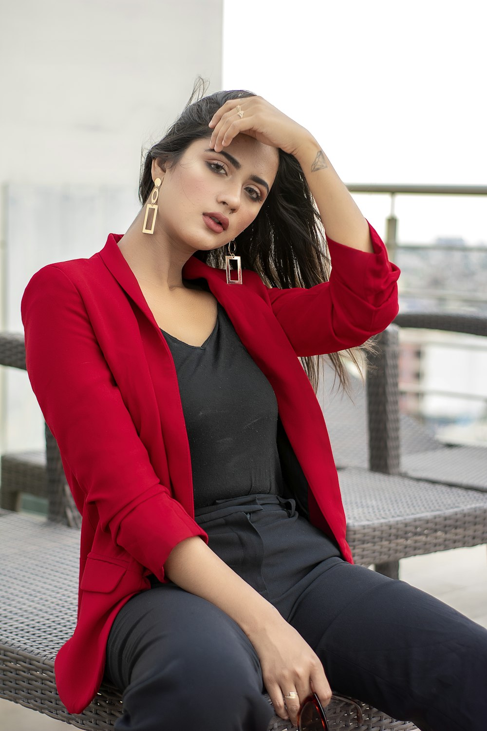 woman in red blazer and black shirt sitting on the floor