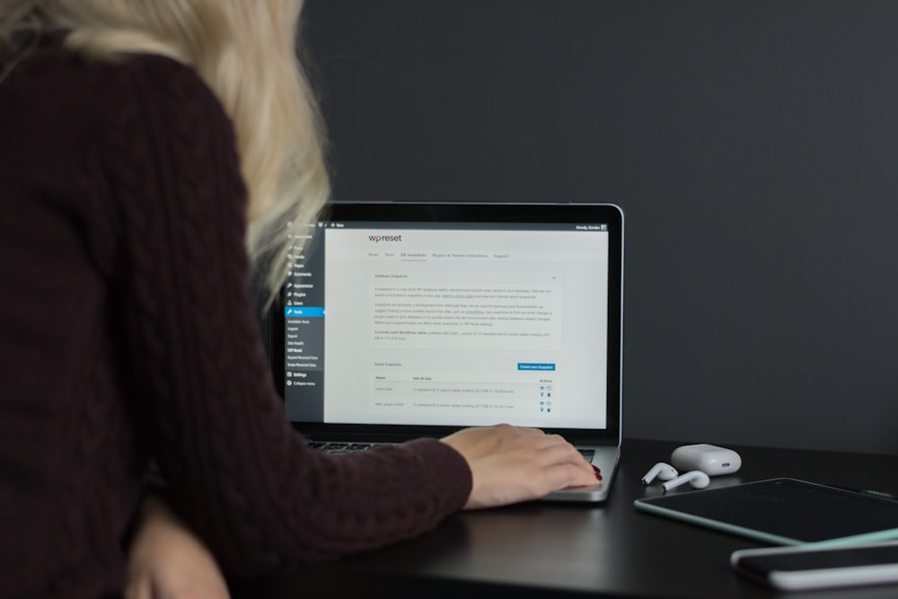 Frau im schwarzen Pullover mit MacBook Pro