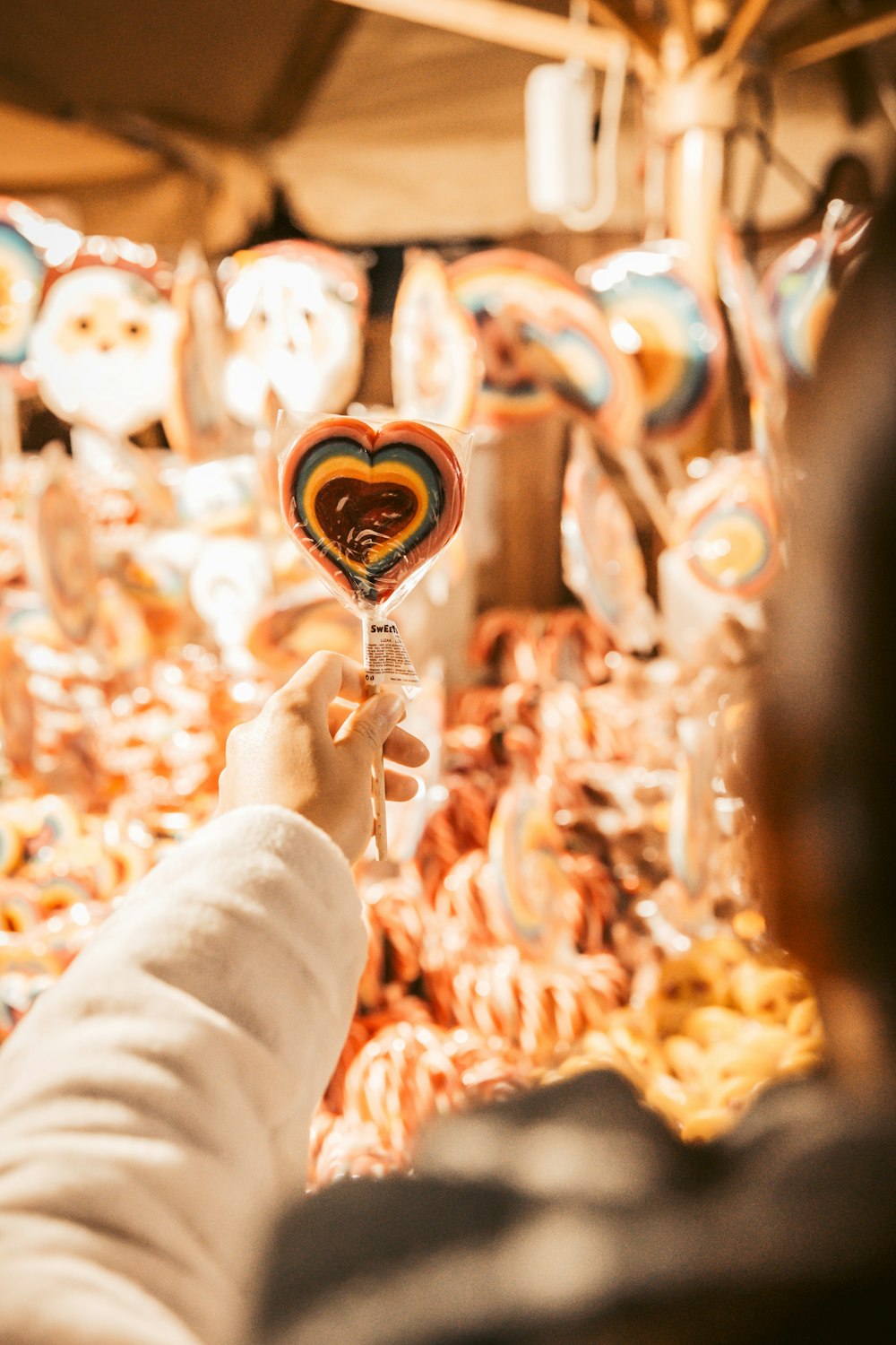 person holding brown and white lollipop