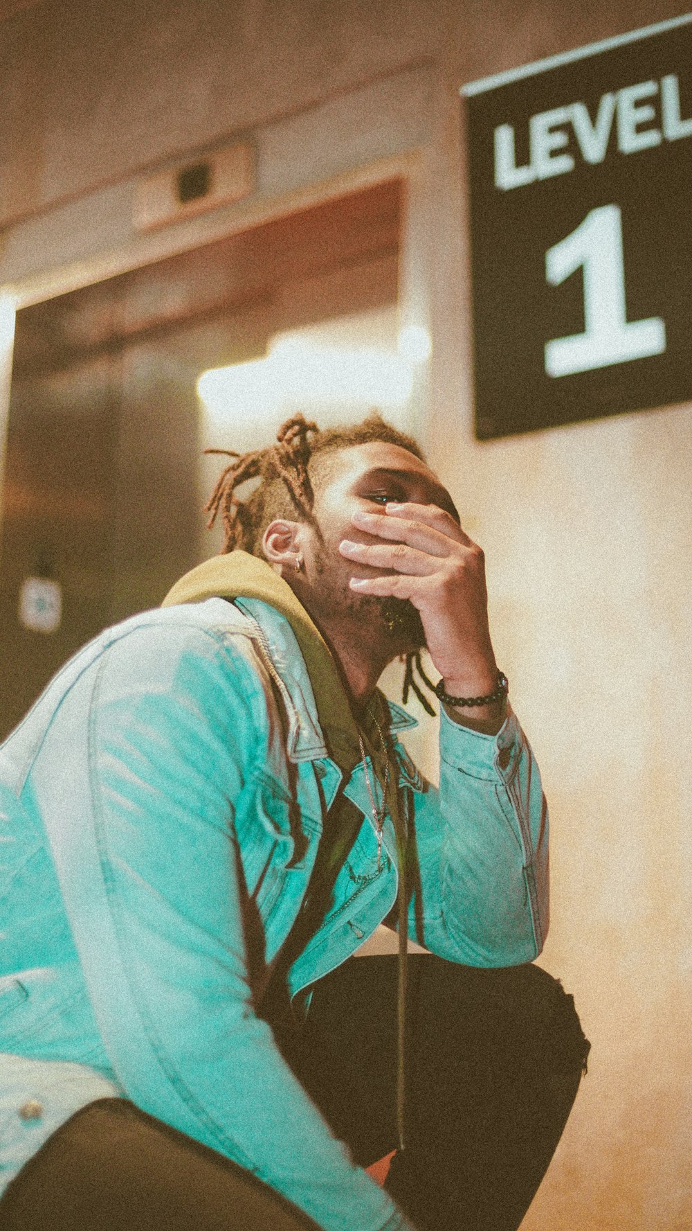 woman in blue long sleeve shirt covering her face