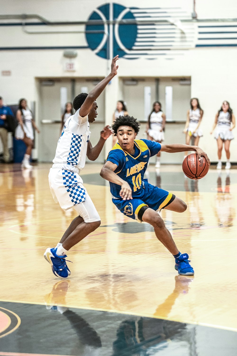 2 women in white and blue jersey shirt playing basketball