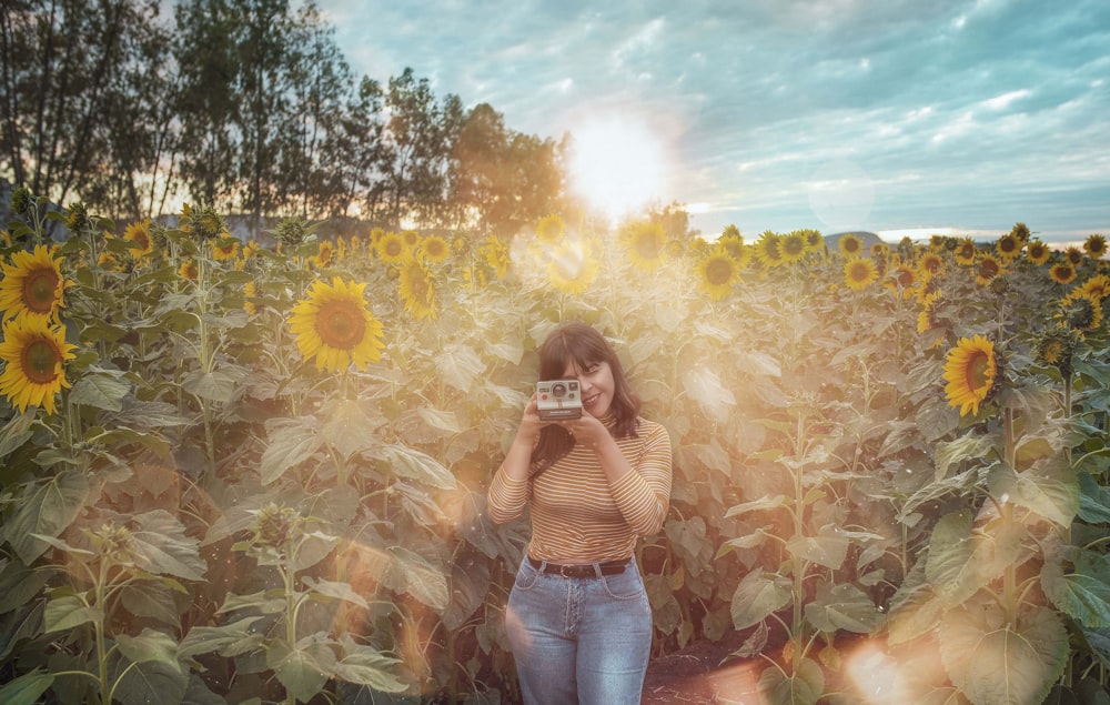 woman in blue denim shorts standing on sunflower field during daytime