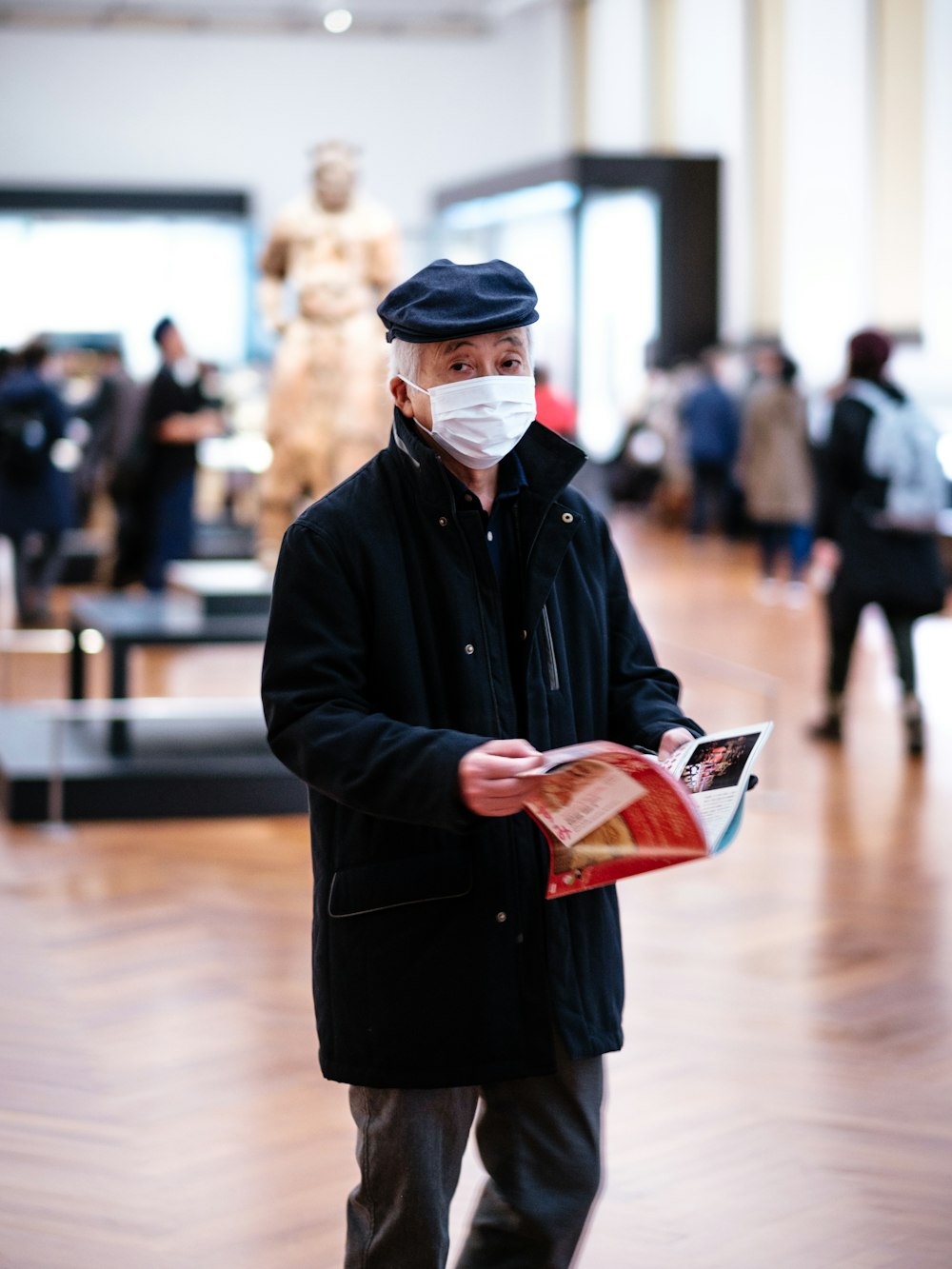 man in black coat holding book