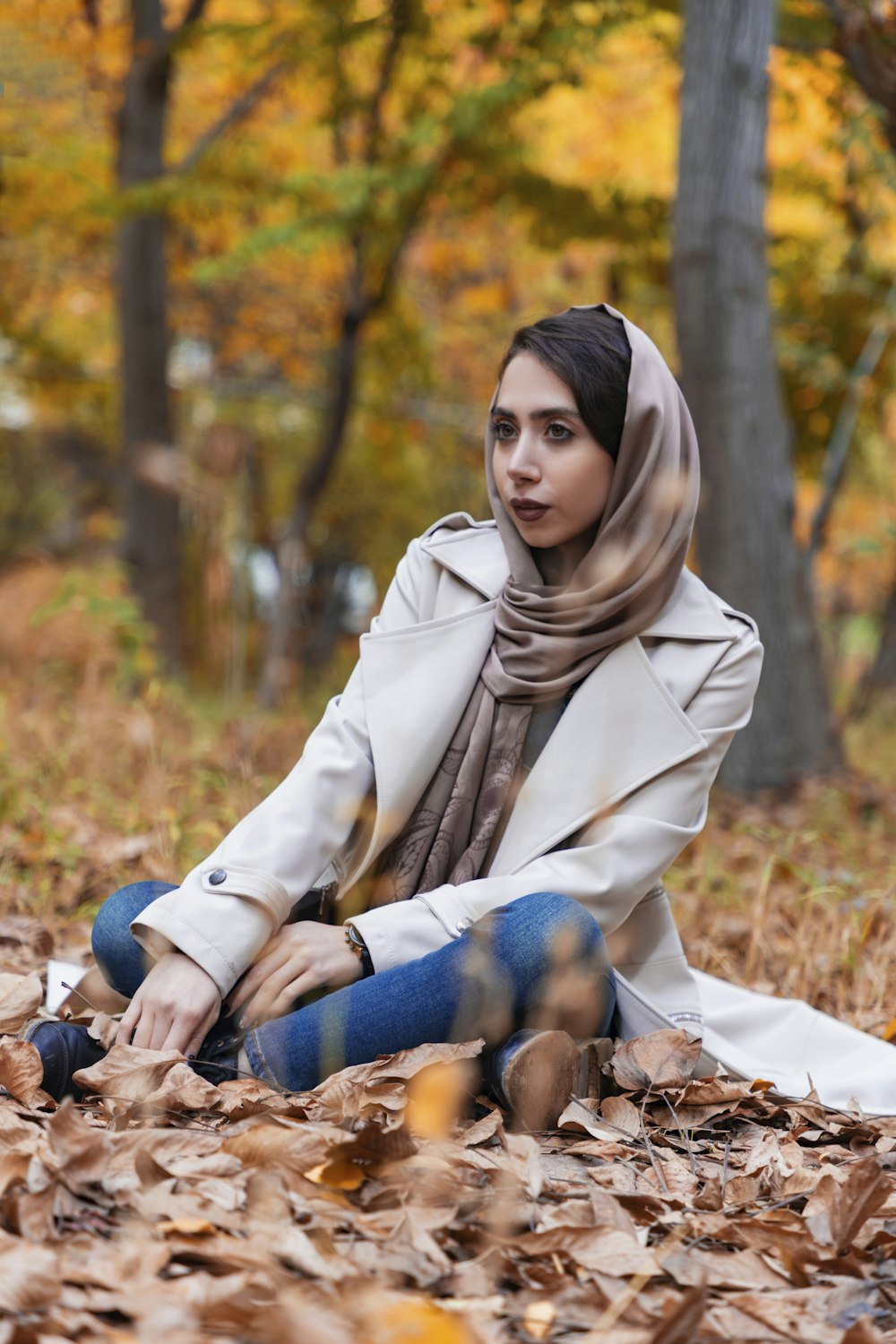 woman in white coat sitting on ground