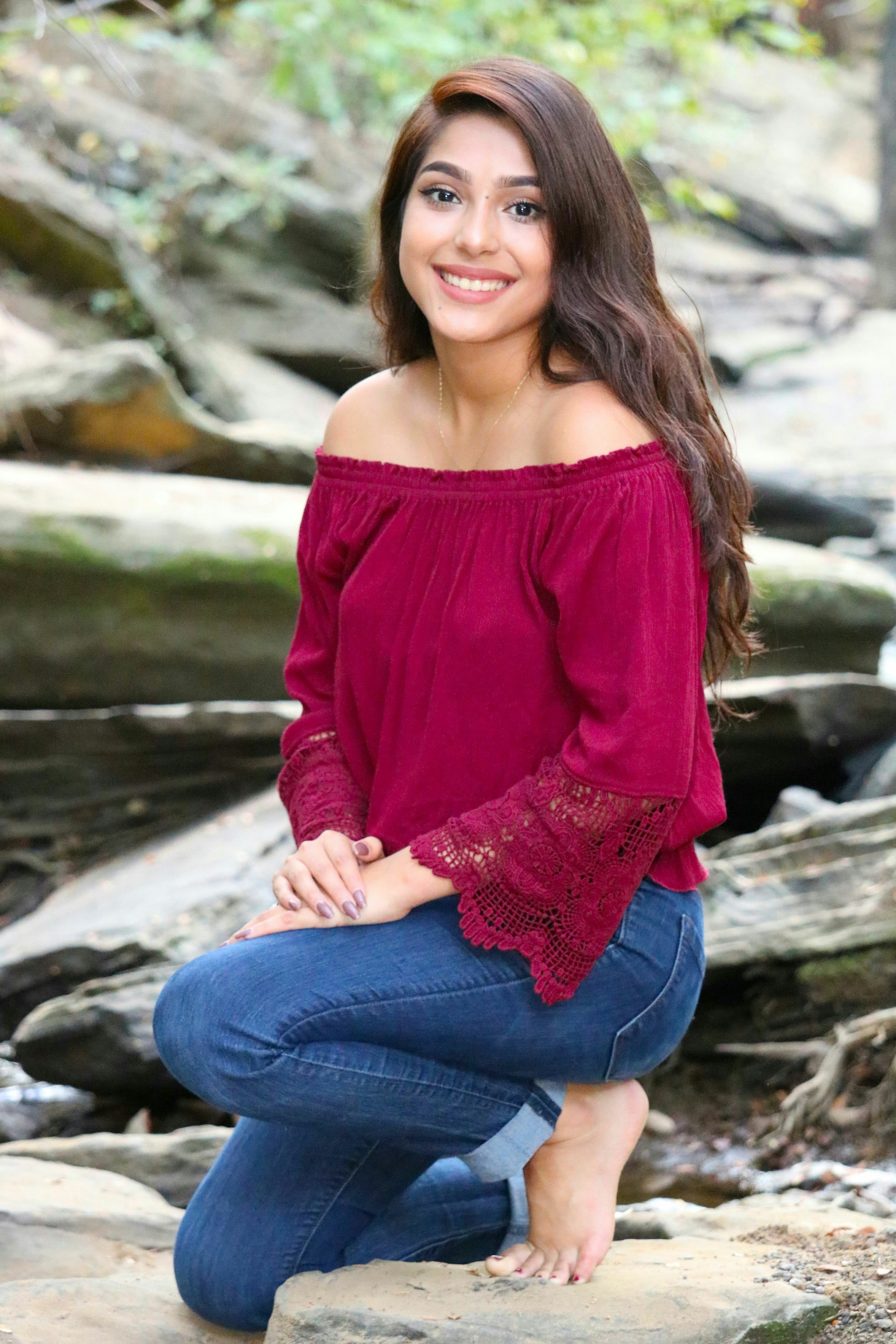 Woman in red off shoulder long sleeve shirt and blue denim jeans ...