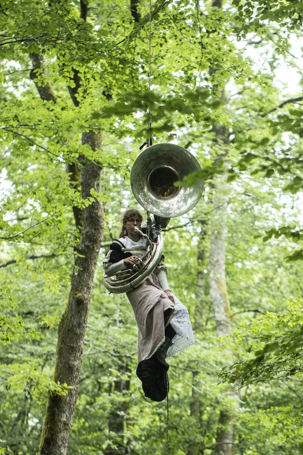 man playing trumpet in forest during daytime