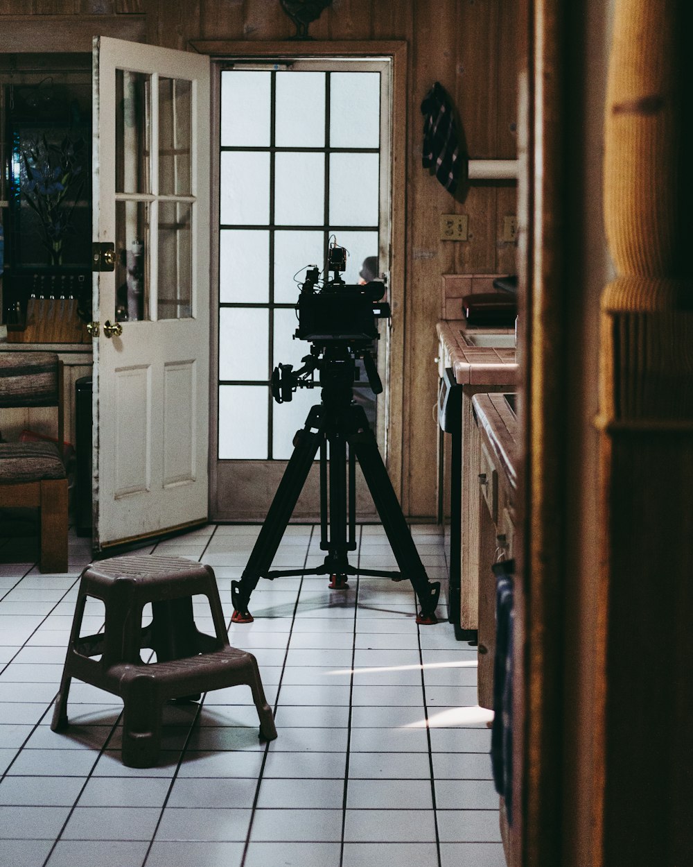 black camera on tripod near brown wooden chair