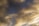 A flock of birds flying in a V-formation against a backdrop of dramatic clouds with a mix of dark and illuminated areas, creating a contrast between the deep blue sky and the golden hues of the clouds.