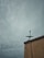 A cloudy sky looms over a building with a satellite dish installed on the edge. The building's wall shows signs of age with visible cracks. The atmosphere seems heavy and overcast, suggestive of an impending storm.