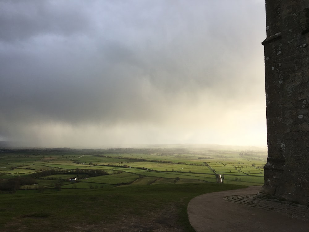 campo di erba verde sotto nuvole bianche