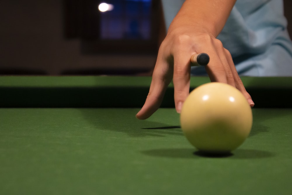 person holding green billiard ball