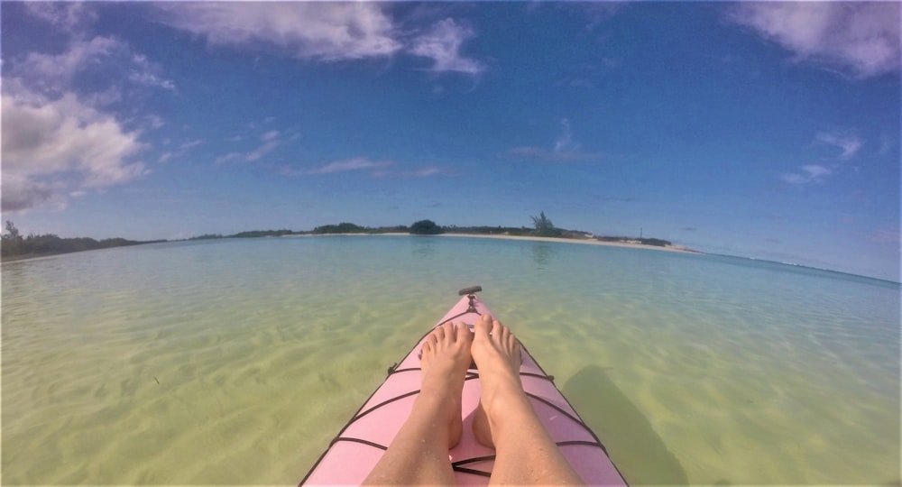 woman lying on beach sand during daytime