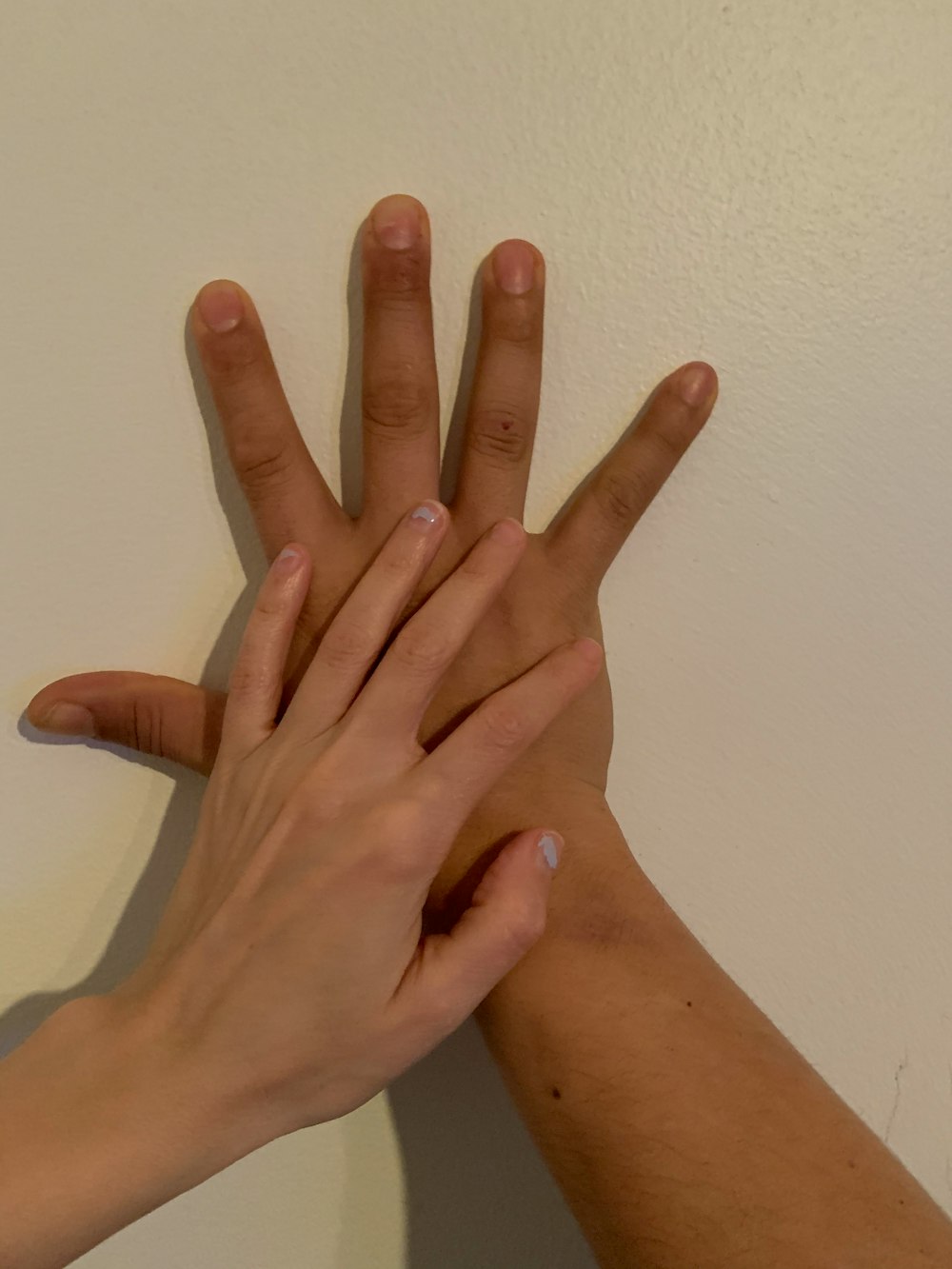 persons left hand on white wall