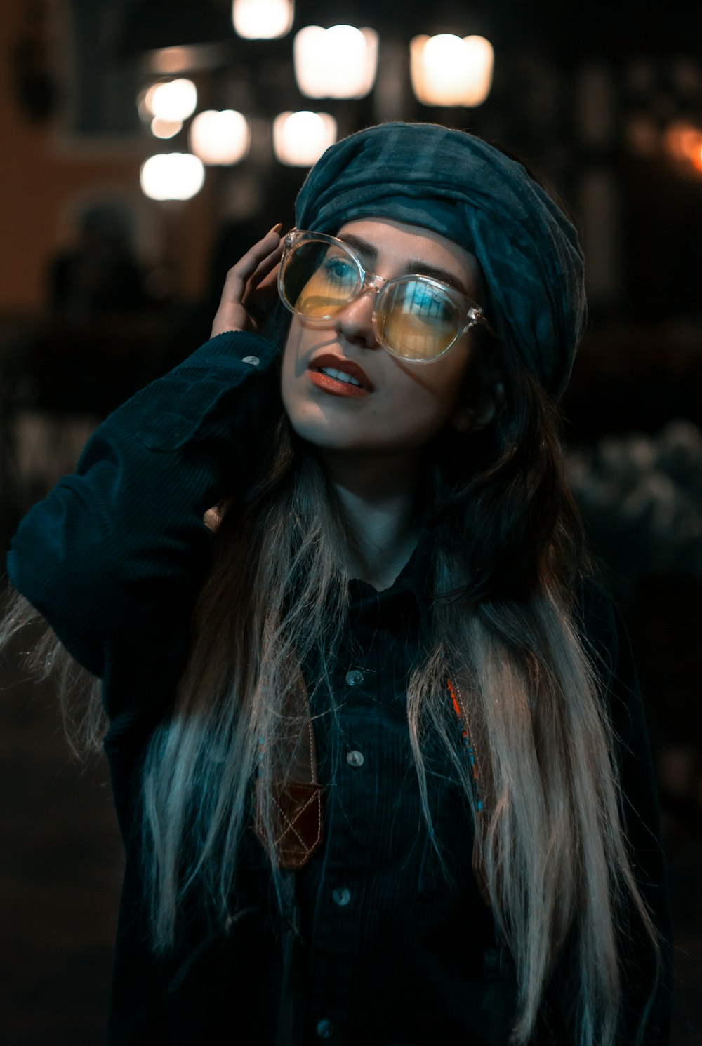 woman in black jacket wearing blue framed eyeglasses