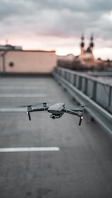 A drone flying over a parking lot scanning ground vehicles with blockchain-enabled passes.