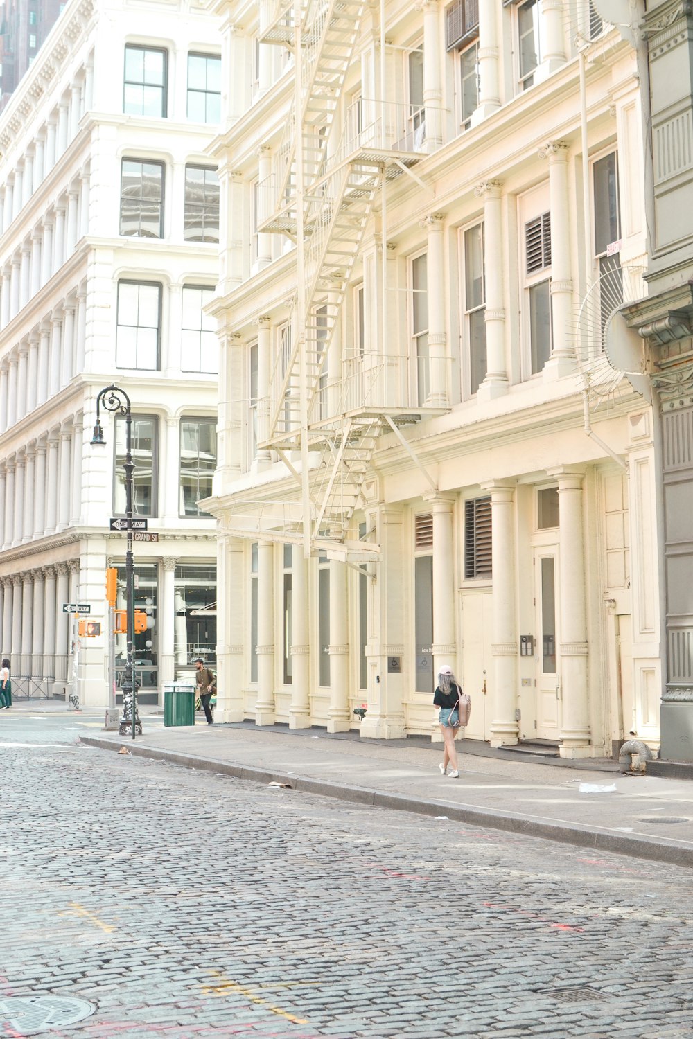 woman in black jacket walking on sidewalk during daytime