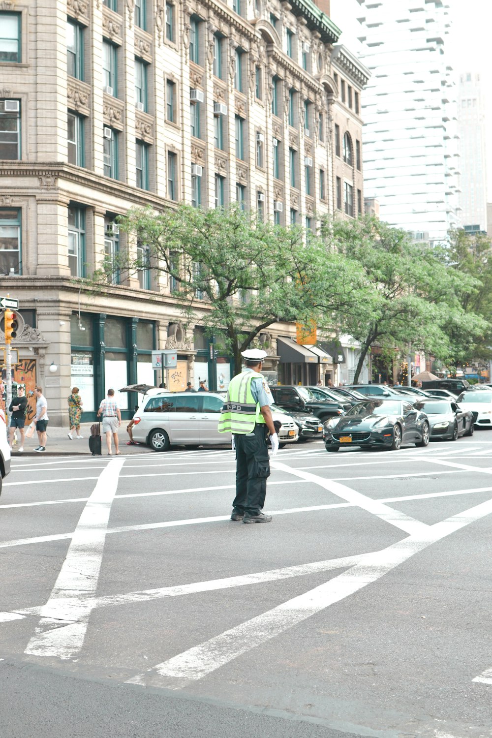 man in green jacket and black pants walking on pedestrian lane during daytime