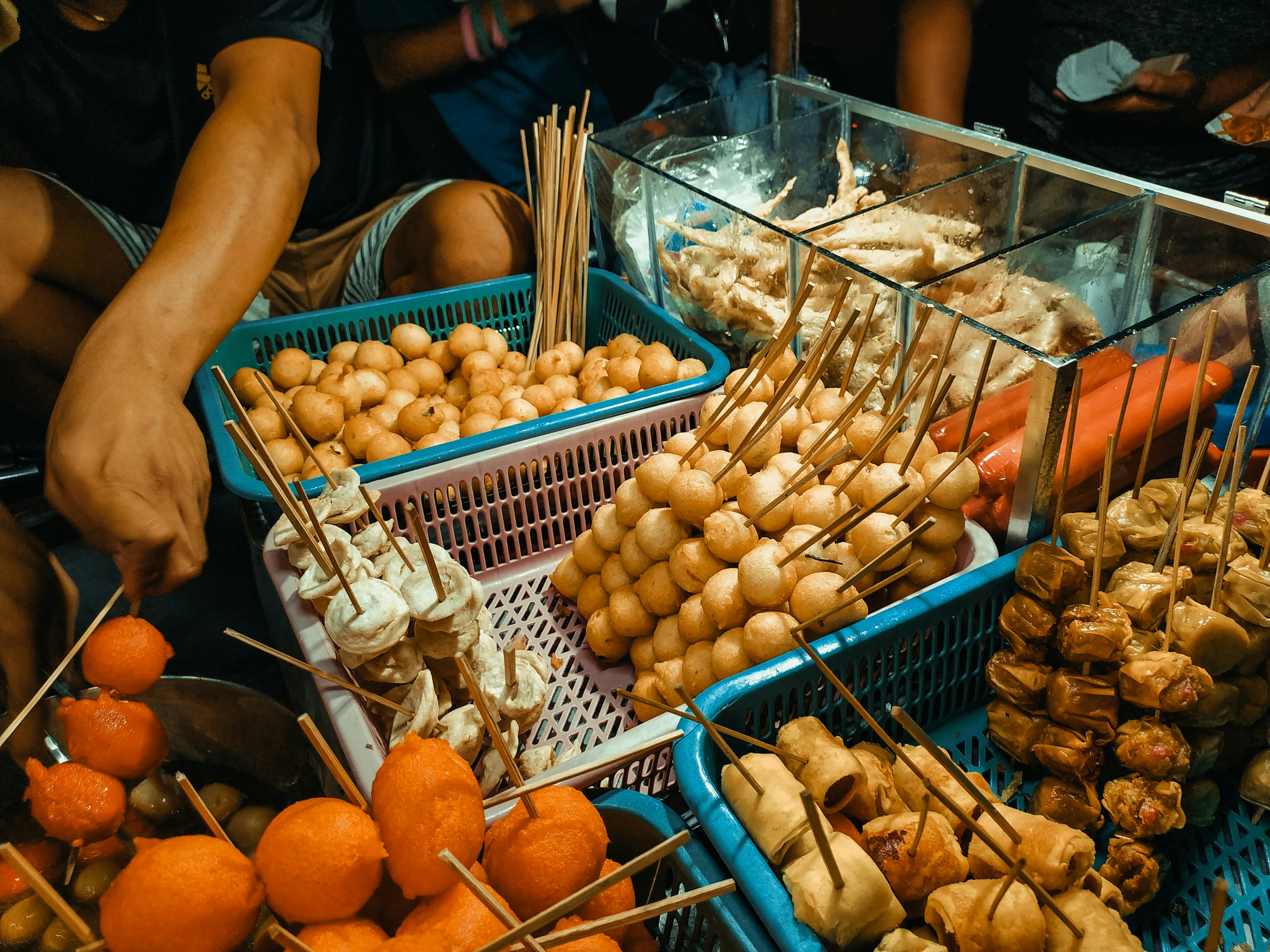 person holding a tray of orange fruits, Asian street food