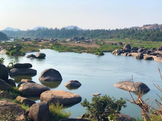 brown rocks on river during daytime in Hampi India