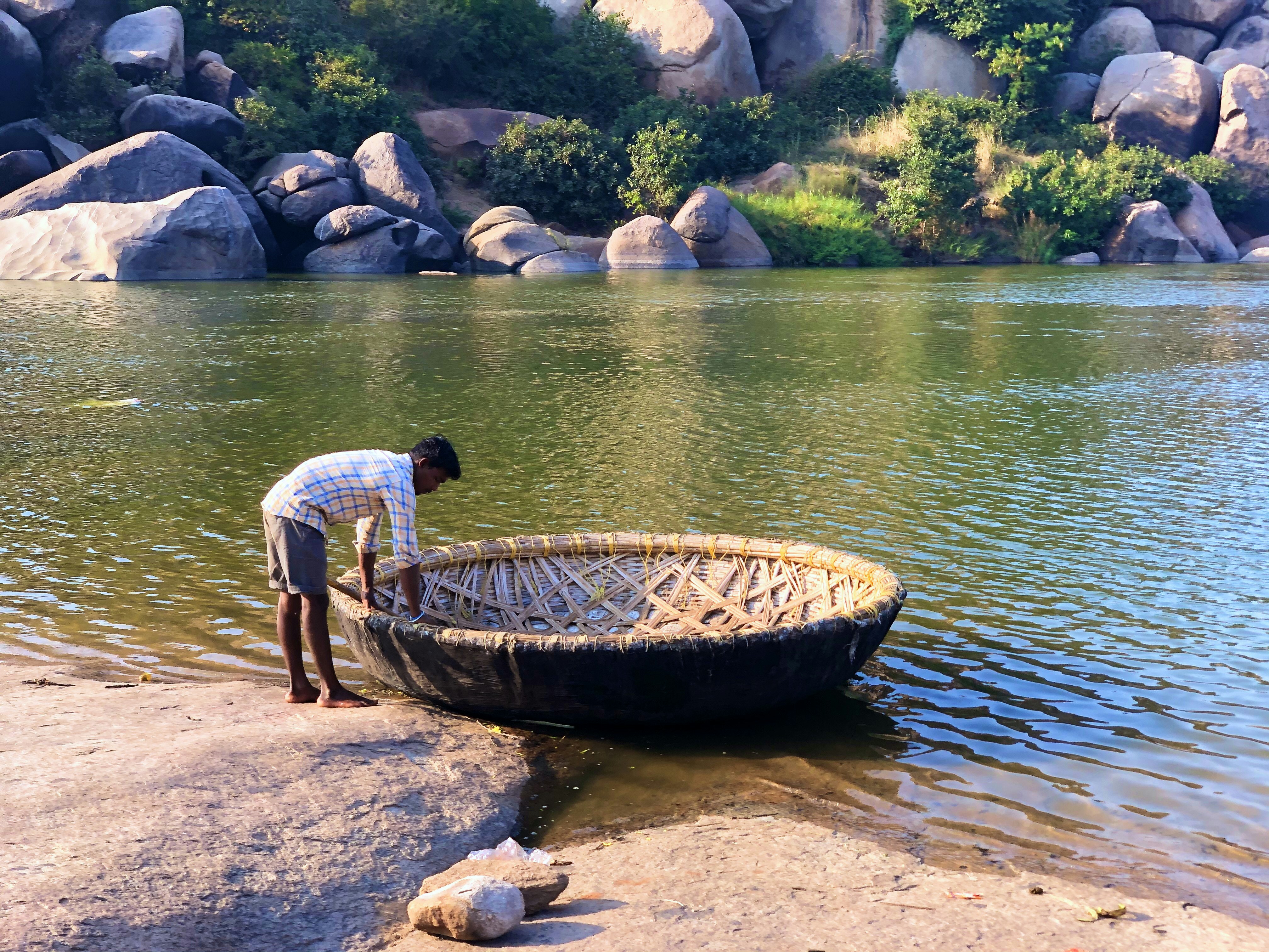 man in white shirt and blue denim jeans standing on brown wooden boat on body of near near near near