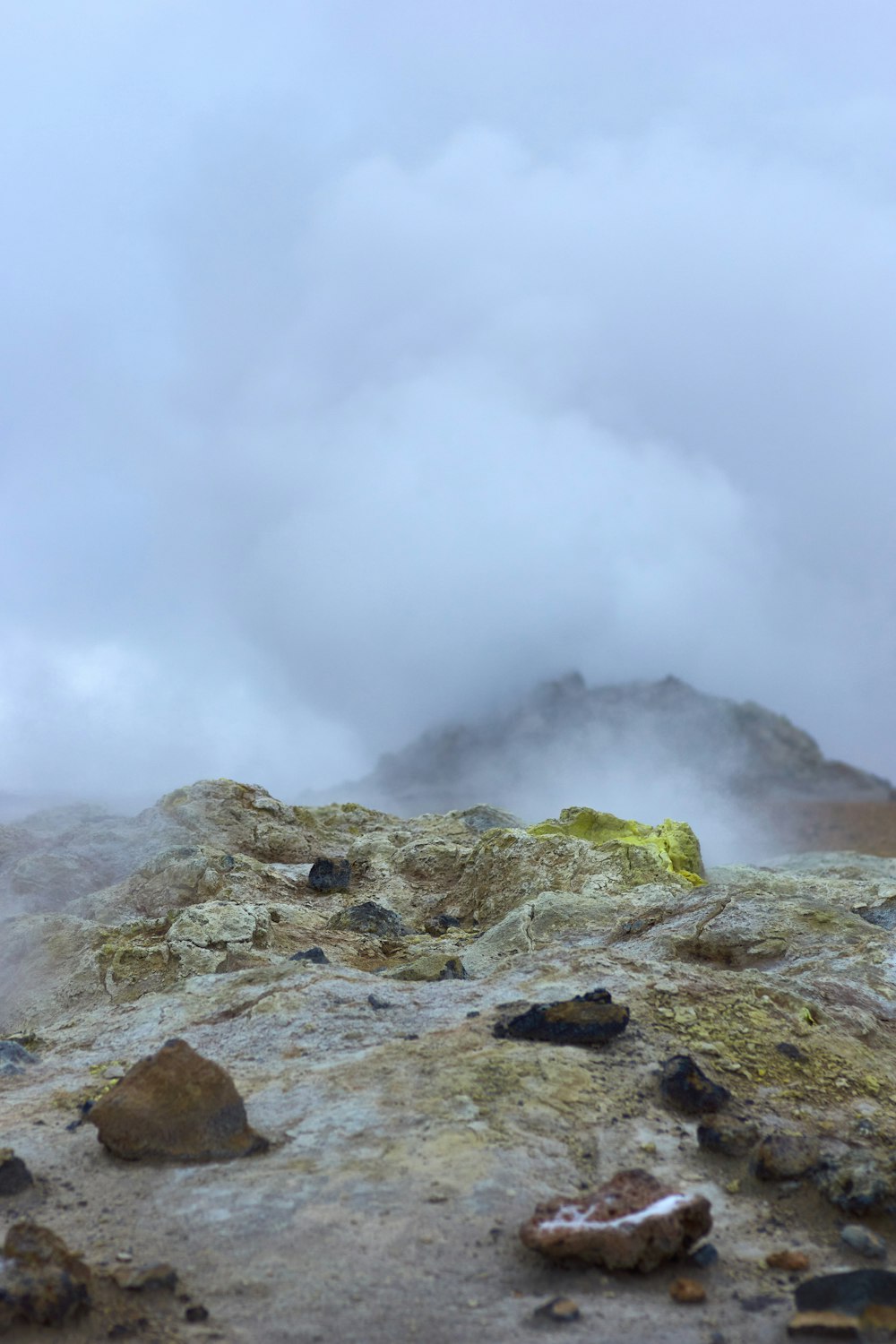 green and brown rock formation under white clouds