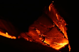Close-up of glowing mesquite charcoal embers with warm orange and red flames
