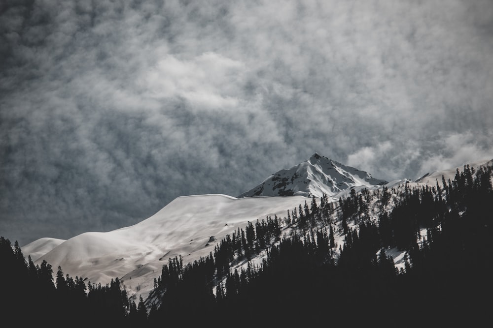 snow covered mountain under cloudy sky during daytime