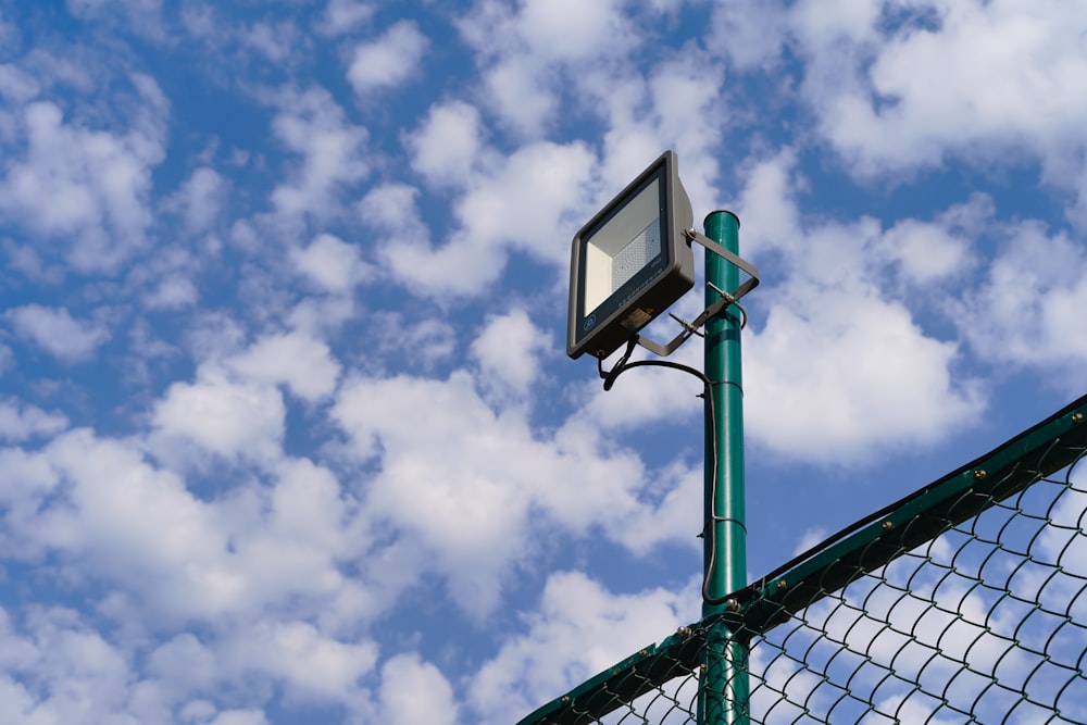 black and white basketball hoop under white clouds and blue sky during daytime