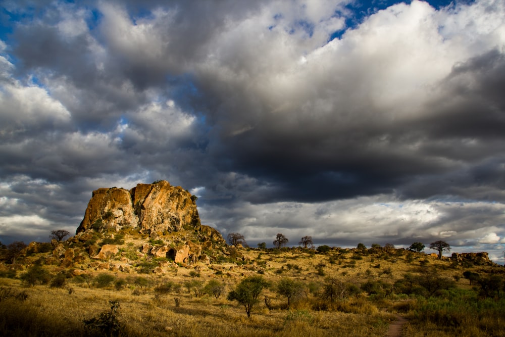 brown rock formation under white clouds and blue sky during daytime