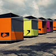 A row of container shops set up in a community market, each with unique branding and inviting entrances.