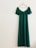 An elegant party dress displayed on a hanger against a pastel-colored wall.