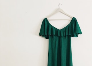 green sleeveless dress hanged on white wall