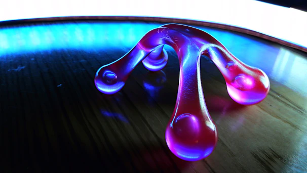 A sleek, modern vibrator glowing softly on a velvet cushion.