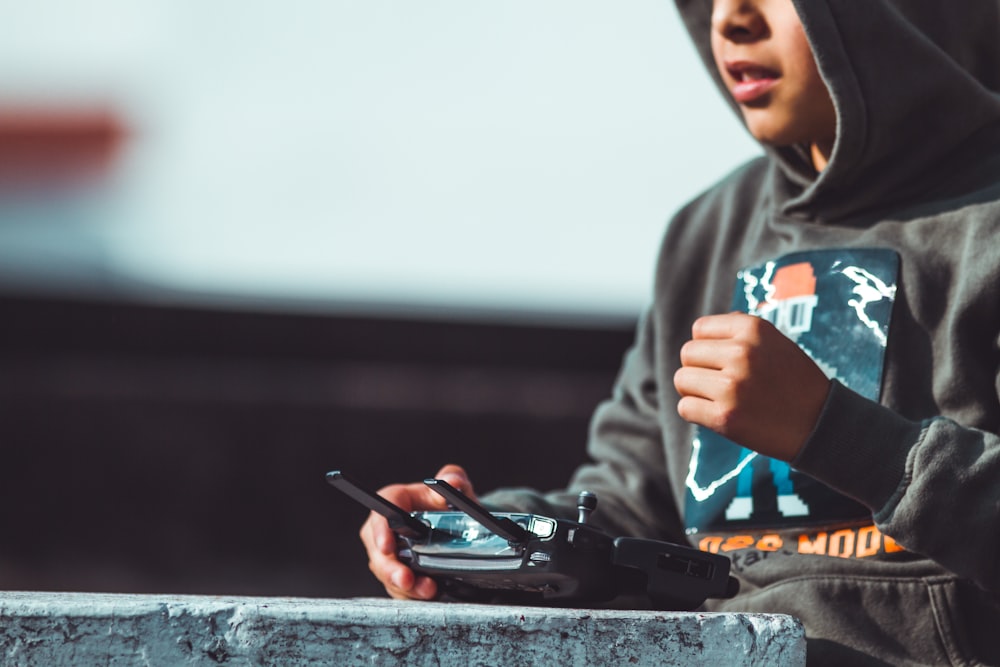 woman in gray hoodie using smartphone