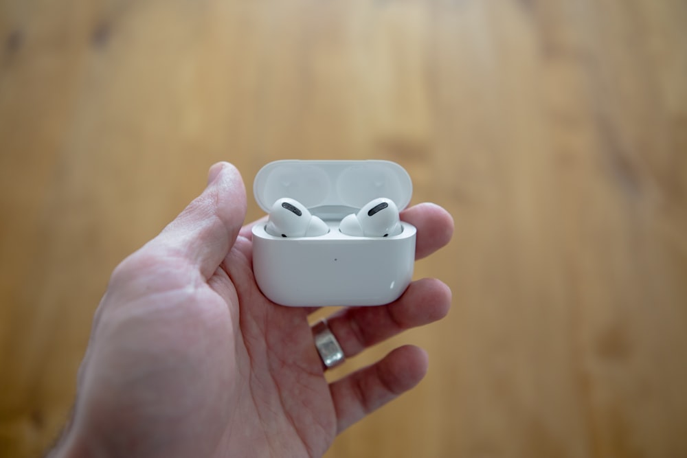 person holding white apple earpods