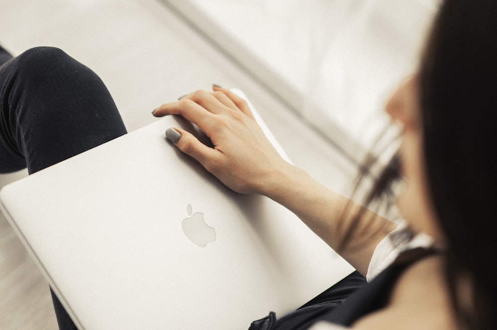 person holding silver macbook on lap