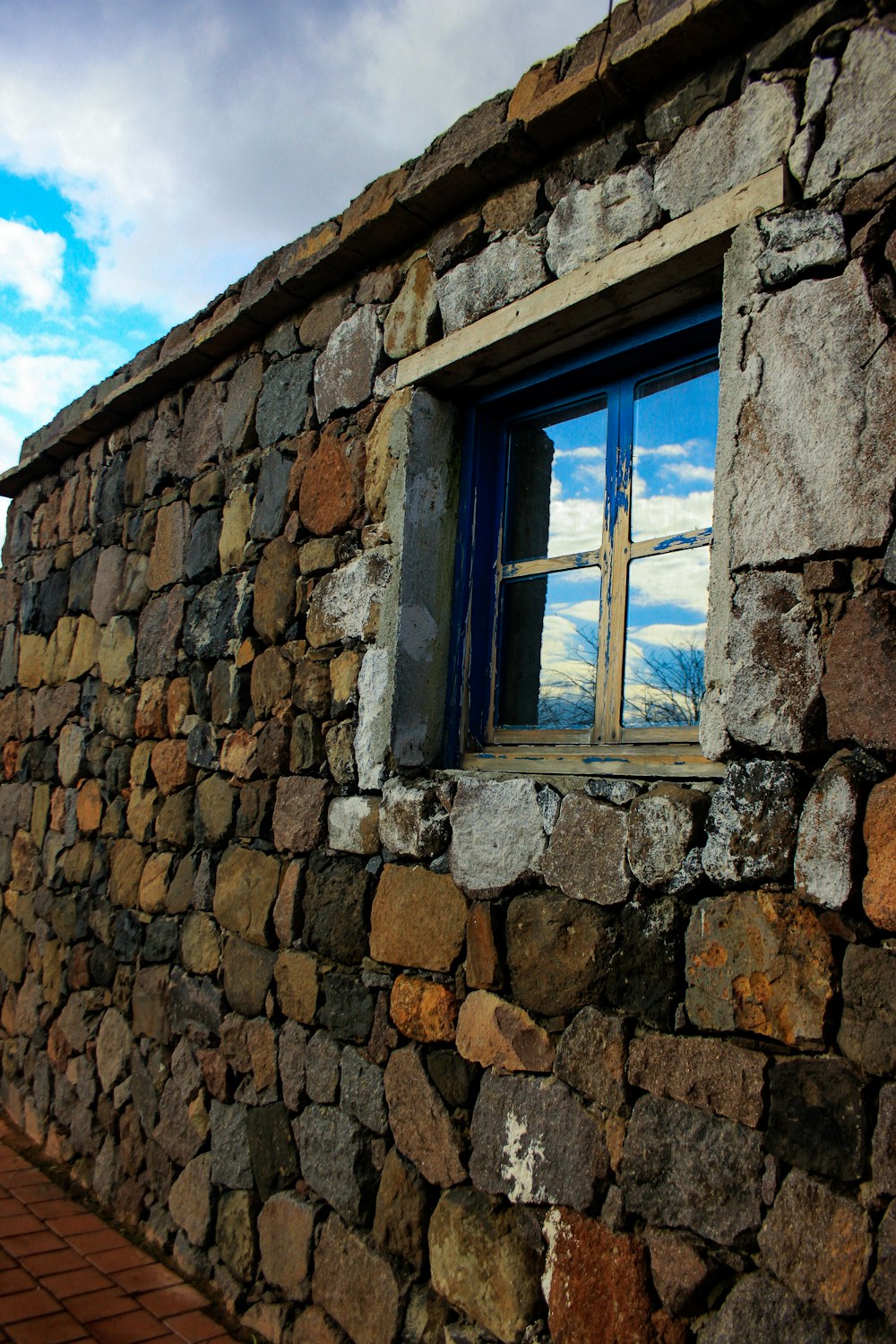 brown brick wall with blue window