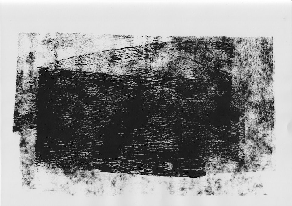 Abstract image of black ink smeared or stamped in a vague rectangle across a canvas.