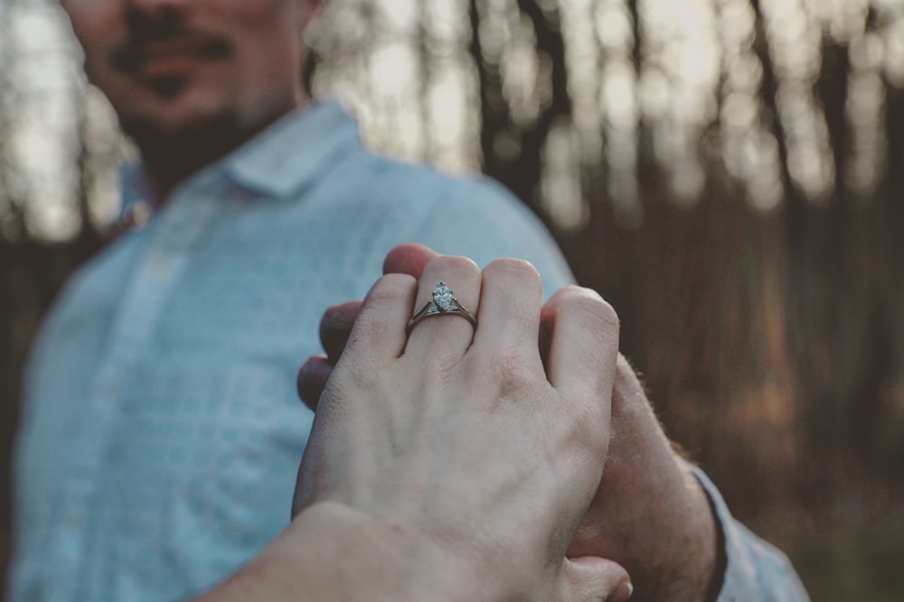 person wearing silver diamond ring