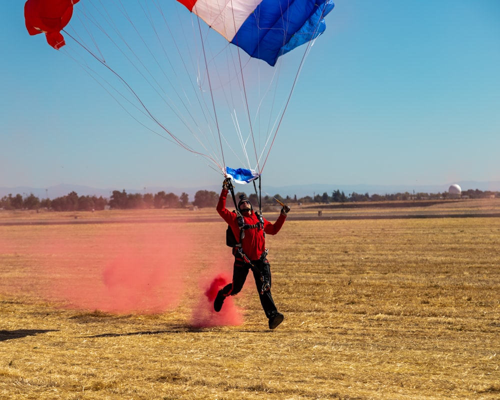 man in red shirt and black shorts riding red and yellow parachute
