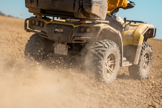 yellow and black front loader on beach during daytime in Gers France