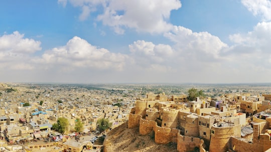 brown concrete building near body of water during daytime in Golden City Fort Jaisalmer India