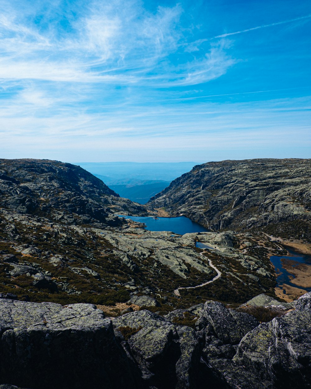 river between mountains under blue sky during daytime