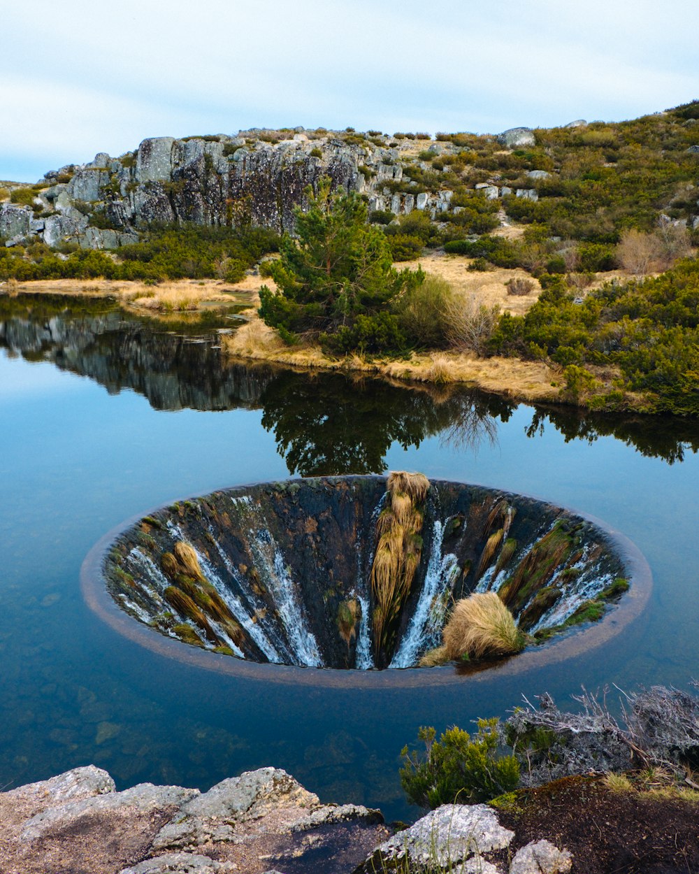 brown rock formation on body of water during daytime